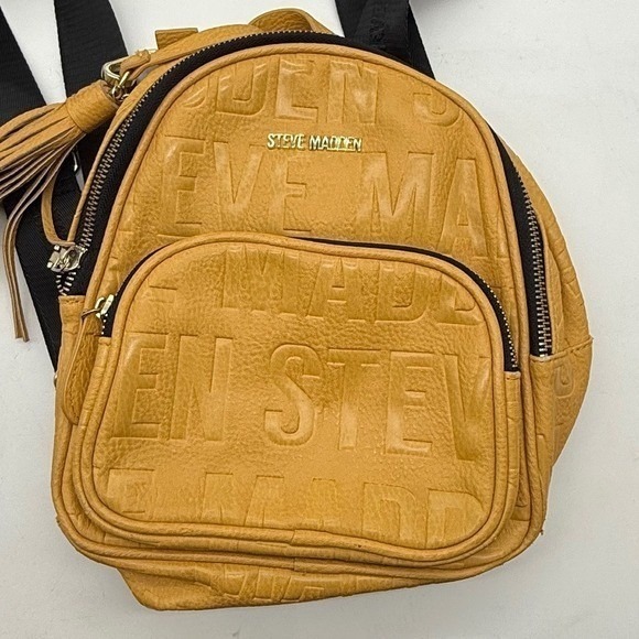Steve Madden Handbags - Steve Madden Yellow Embossed Logo Mini Backpack Mustard Tassel -corner peeling